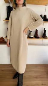Vestido midi color beige de tejido acanalado, con cuello alto y mangas largas.