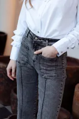 Pantalón de jean gris oscuro con corte recto, bolsillos delanteros y alforza central.