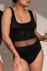 Body negro de musculosa con escote cuadrado, detalle de microtul y brillos, con broches en entrepierna.