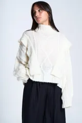 Sweater blanco de punto con cuello alto, diseño de ochos y volados en los hombros.