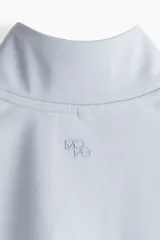 Campera deportiva corta celeste con cuello alto, cierre frontal, mangas largas con orificios para los pulgares y tecnología SoftMove™ y DryMove™.