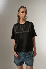 Blusa negra de poliéster con cuello redondo y corte ancho.