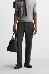 Pantalón chino negro slim fit confeccionado en tejido técnico de secado rápido. Cuenta con bolsillos frontales y traseros de vivo. Cierre frontal con cremallera y botón.