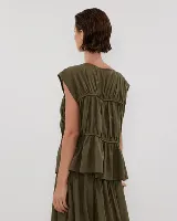 Blusa negra con escote redondo, sin mangas y detalle de frunces horizontales en el frente.