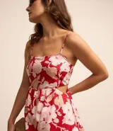 Vestido midi evasé con breteles finos ajustables, escote recto, recortes abiertos laterales, capas superpuestas en volados y estampa floral.