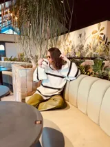 Sweater oversized color crema con rayas horizontales negras y mangas anchas con detalle de crochet.