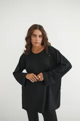 Conjunto verde oliva de punto morley, compuesto por un buzo de corte holgado con mangas largas y aberturas laterales, y un pantalón palazzo de tiro alto.