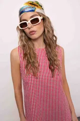 Vestido corto con estampado de cuadros rojos y blancos, cuello redondo y sin mangas.