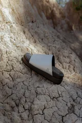 Sandalia tipo slide de plataforma, color gris claro metalizado, con una tira ancha y suela gruesa de goma color negro.