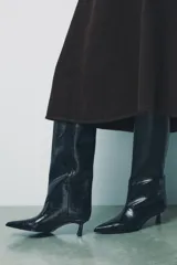 Bota de caña alta color negro de cuero sintético, con punta fina y tacón kitten.