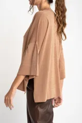 Sweater color cobre brillante, de tejido de punto con lurex, corte oversize, cuello redondo y mangas 3/4 con volados.