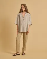 Camisa color gris claro, de manga 3/4, tela ligera, cuello camisero con solapa y escote en V.