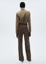 Pantalón de vestir marrón con pinzas, tiro medio, corte recto y bolsillos laterales. Incluye trabillas para cinturón, cierre oculto con botón, gancho y cremallera, botón decorativo y bolsillo de ribete en la parte posterior.