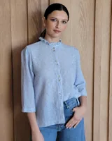 Camisa blanca de mangas 3/4 con cuello mao y botones frontales.
