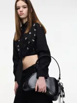 Camisa cropped negra de algodón con botones frontales, lazos para atar en la cintura, elástico en el bajo y apliques de pedrería.