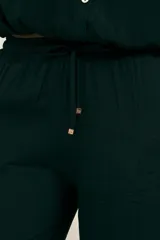 Pantalón negro de crepe con corte recto, cintura elastizada, bolsillos laterales y terminaciones en cobre.