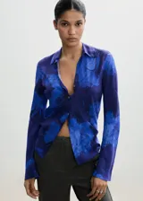 Camisa azul con estampado floral, de corte recto, cuello camisero y manga larga.