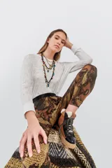 Pantalón babucha con estampado de piel de serpiente en tonos marrones y negros, con cintura alta elástica en color negro.