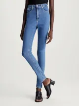 Jeans de denim elástico de tiro alto, corte skinny, color azul medio. Cuenta con bragueta con cremallera, diseño de cinco bolsillos y herrajes de Calvin Klein.