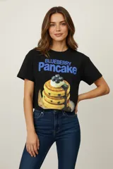 Remera negra de algodón con estampado de un plato de panqueques con arándanos.