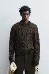 Sweater marrón oscuro de punto con estructura de trenzas, cuello redondo, manga larga y corte regular fit.
