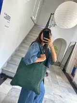 Bolso tote de cuero color marrón con diseño entrelazado.