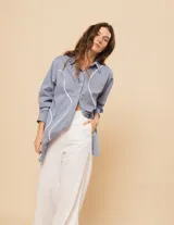 Camisa oversized de algodón, con botones a tono y cortes en ondas decorativos en el delantero.