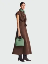 Bolso de mano verde con cierre metálico plateado.