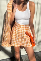Short estilo sastrero con estampado a cuadros color naranja y blanco.