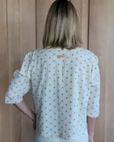 Camisa color beige claro con cuello con volados y mangas 3/4 abullonadas.