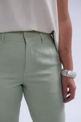 Pantalón verde lima de corte recto, con bolsillos laterales y cierre frontal con botón y cremallera.