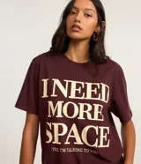 Remera alargada color bordó con cuello redondo y mangas cortas. Estampa frontal con la frase "I NEED MORE SPACE, YES, I'M TALKING TO YOU" en color crema.