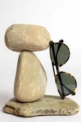 Lentes de sol negros con montura aviador y lentes grises.