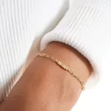 Pulsera dorada de acero quirúrgico con baño de oro 18k y cadena de eslabones ovalados. Dije con la palabra “mamá”.