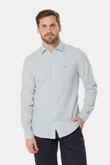 Camisa de manga larga, color celeste con finas rayas blancas, confeccionada en una mezcla de lino y algodón. Presenta un corte slim fit y no tiene bolsillo.