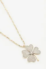 Collar largo dorado con dije de trébol de cuatro hojas con strass.