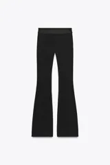 Pantalón negro de tiro medio, confeccionado en tejido elástico con cintura elastizada y corte acampanado.