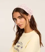 Bandana elástica con estampado de cuadros vichy color lila y flores blancas.