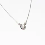 Collar plateado con cadena fina y dije ovalado de ópalo blanco.