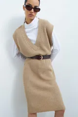 Vestido tejido color beige con escote en V y diseño acanalado.