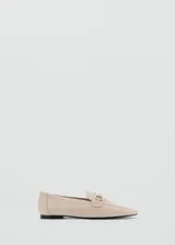 Mocasín de cuero color camel con punta fina y detalle de hebilla metálica dorada.