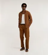 Pantalón masculino de sarga color marrón, de corte recto, con cintura con trabilla, cierre tradicional y bolsillos.