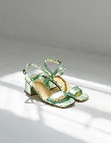 Sandalia de cuero vacuno color verde agua metalizado, con dos tiras en el empeine y tobillo con hebilla ajustable. Taco cuadrado de 4 cm.