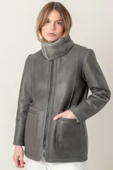Campera de cuero color gris con cuello de piel sintética y cierre frontal con cremallera.