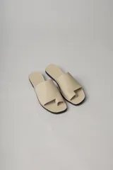 Sandalias planas de cuero color negro, con tira ancha sobre el empeine y diseño minimalista.