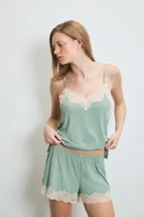 Conjunto de pijama color verde agua, compuesto por un camisón de tirantes y un short. Ambos tienen detalles de encaje color crema en el escote y en el ruedo.