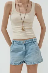 Shorts blancos de tiro medio con trabillas, bolsillos laterales y traseros. Cierre frontal con cremallera y botón metálico.