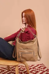 Cartera mochila color tostado, símil cuero, con compartimiento principal amplio y bolsillos frontales con cierre. Tiene correas ajustables para usar como mochila y asa superior para llevar al hombro.