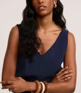 Musculosa sin mangas confeccionada en viscosa sostenible, con escote en pico y corte vertical.