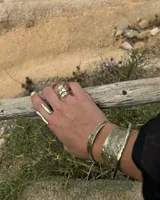 Brazalete ancho de bronce macizo con textura irregular.